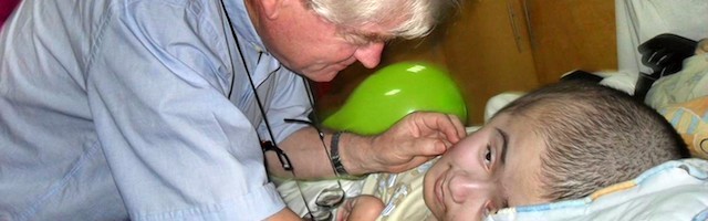 Aldo Trento, junto a un niño con hidrocefalia atendido en uno de sus centros.