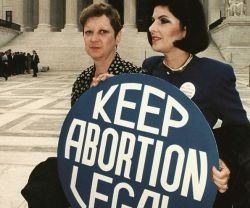 Norma McCorvey en 1989 -junto a la abogada con la pancarta- cuando aún era pro-aborto