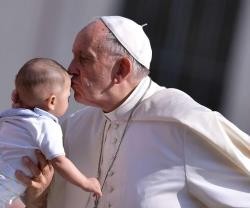 El Papa Francisco besa un bebé que le presentan en la audiencia del miércoles
