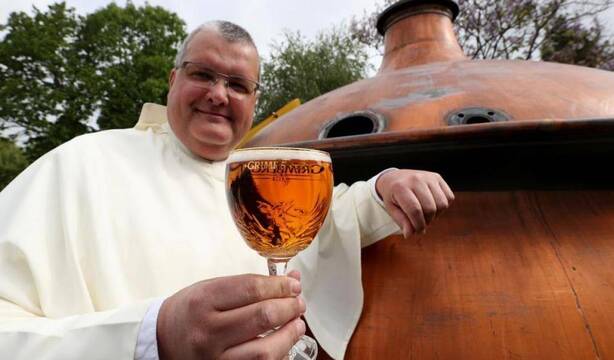 Un monje belga muestra una de las cervezas que produce su abadía