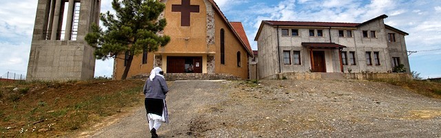 Una mujer camina hacia la iglesia en Daj (Albania). Foto: Carminemeo.com