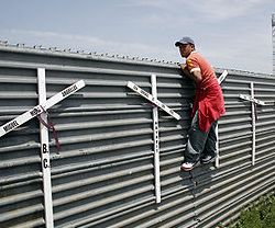 Un hombre se asoma a la frontera entre San Diego y Tijuana, entre México y EEUU