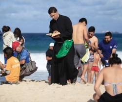 Un religioso lee el breviario en la playa... durante la JMJ de Rio de Janeiro