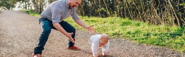 Un padre enseña a andar a su hijo.
