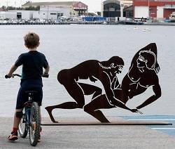 Un  niño observa desde su bici una de las polémicas esculturas expuestas en pleno paseo en Valencia