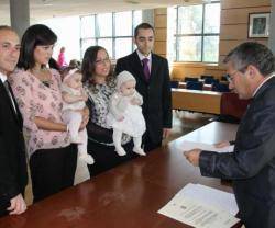 Una ceremonia de acogida civil municipal en Moaña, Galicia... el alcalde lee unos papeles...
