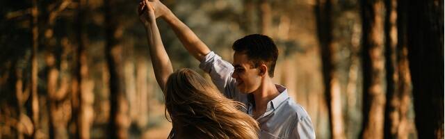 Una pareja danza en el bosque tomados de la mano en una foto de Scott Brume para Unsplash