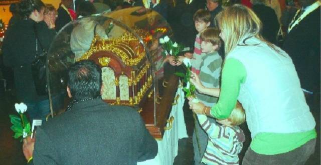 La familia Paulson, con Kate y sus tres hijos, venerando las reliquias de Santa Teresita.