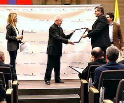 El padre Martínez Puche recibe el Premio Religión en Libertad de manos del sacerdote Pablo Cervera.