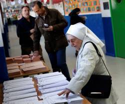 Una religiosa selecciona papeletas para votar... en las elecciones generales en España hay más opciones que nunca, pero siempre en listas cerradas y bloqueadas