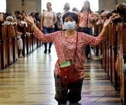 Una mujer reza en una iglesia de Asia... pero en varios países ya no es posible hacerlo en misa... Singapur e Italia, por ejemplo, y ahora Malasia