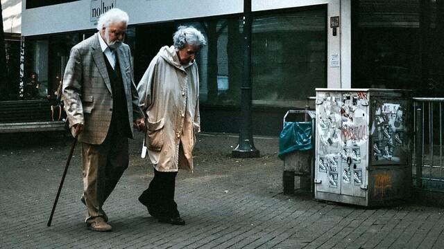 Dos ancianos caminan por la calle.