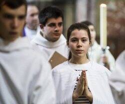 Una catecúmena candidata -con su vestidura blanca- se presenta a la Iglesia solicitando el bautismo