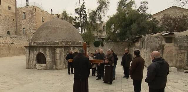 Unos franciscanos acompañan a unos peregrinos por Jerusalén