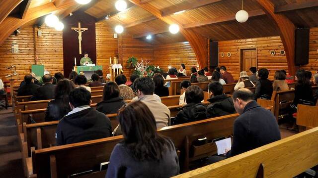 Personas asisten a misa en una iglesia.