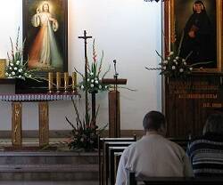 Oración ante el icono de la Divina Misericordia y un retrato de Santa Faustina Kowalska