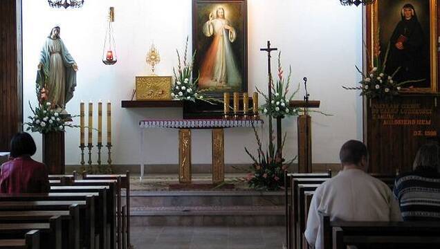 Oración ante el icono de la Divina Misericordia y un retrato de Santa Faustina Kowalska