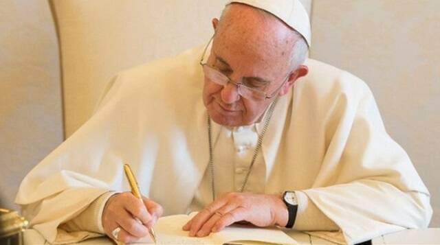 El Papa Francisco escribiendo con un bolígrafo dorado