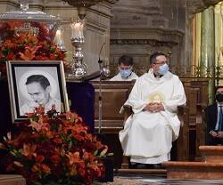 Un sacerdote escucha al obispo Amadeo, de Jaén, junto a una imagen del beato Lolo