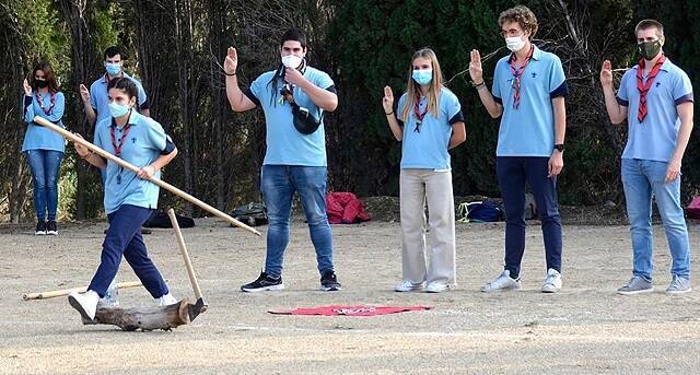 Jóvenes ligados a los marianistas de Zaragoza realizan el saludo scout en una actividad al aire libre