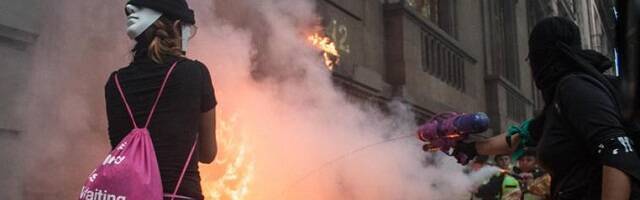 Incendio provocado en una marcha de feministas abortistas en México  - unas encapuchadas echan un chorrito de agua, quizá arrepentidas