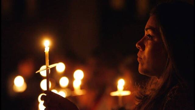 Mujer rezando con una vela