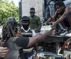 Mujer haitiana recogiendo alimentos de primera necesidad entregados por Cáritas.