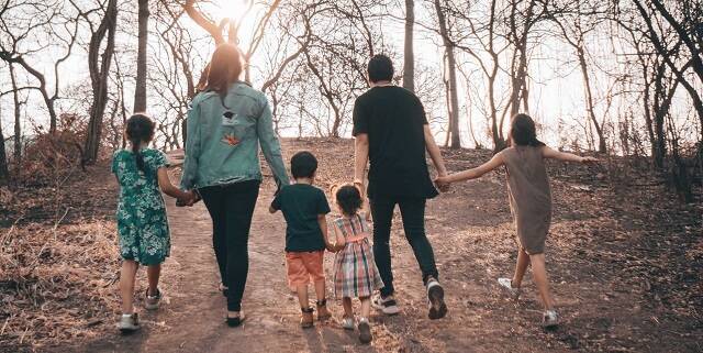 Una familia pasea en el bosque otoñal