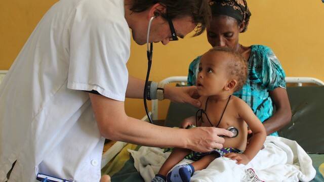 Médico atendiendo a un niño africano.