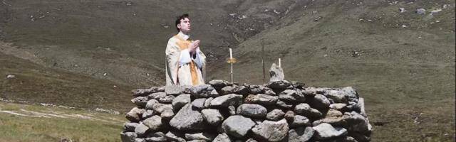 Sacerdote celebrando misa en un altar de roca.
