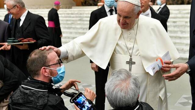 El Papa Francisco bendice a un peregrino que acude a la audiencia en silla de ruedas
