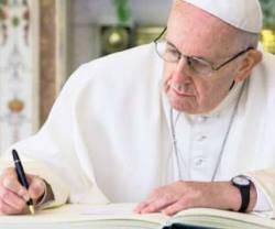 Papa Francisco firmando.