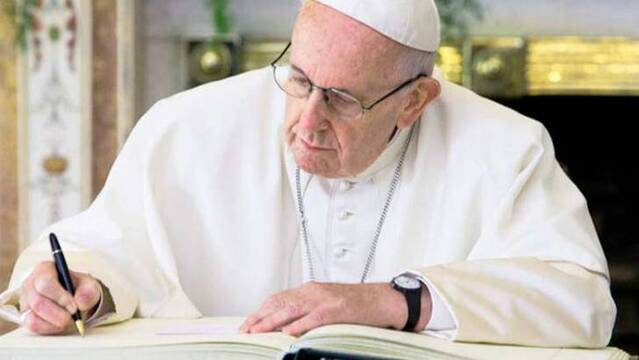 Papa Francisco firmando.