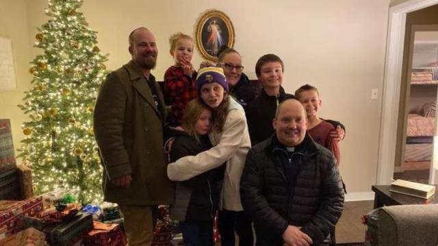 Matt, Cassie, sus hijos y el párroco de Minnesota, Brandon Moravitz. 