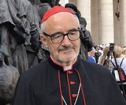 El cardenal Czerny junto a una estatua que representa el drama de los migrantes
