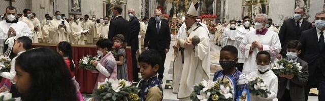 El Papa Francisco traslada al Niño Jesús del altar al belén, acompañado por Niños tras la misa que inicia la Navidad de 2021