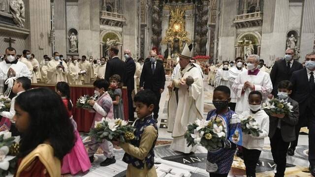 El Papa Francisco traslada al Niño Jesús del altar al belén, acompañado por Niños tras la misa que inicia la Navidad de 2021