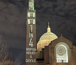 El grupo abortista autodenominado católico aprovechó la vigilia en el santuario nacional para realizar esta profanación en la fachada