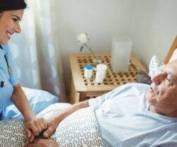 Enfermera cuidando de un anciano.