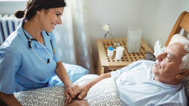 Enfermera cuidando de un anciano.