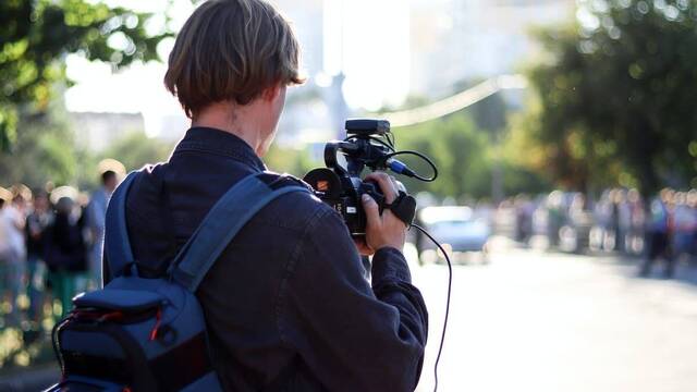 Periodista con una cámara en la calle.