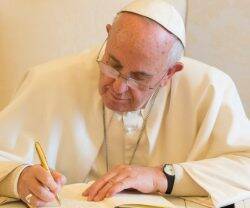 Papa Francisco escribiendo.