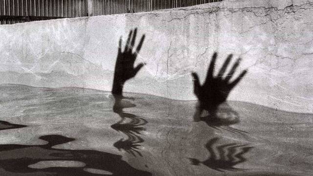 Sombra de las manos de alguien ahogándose.