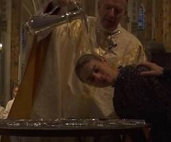 Un obispo bautiza una chica francesa en la catedral