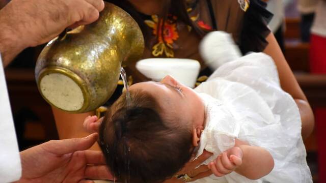 Sacerdote bautizando a un niño.