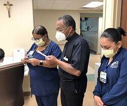 Un capellán reza con unas sanitarias en un hospital de Miami 