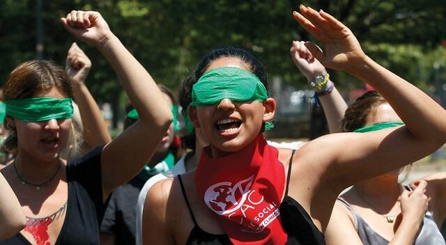 Feministas gritan con pañuelos verde pro-aborto tapándoles los ojos