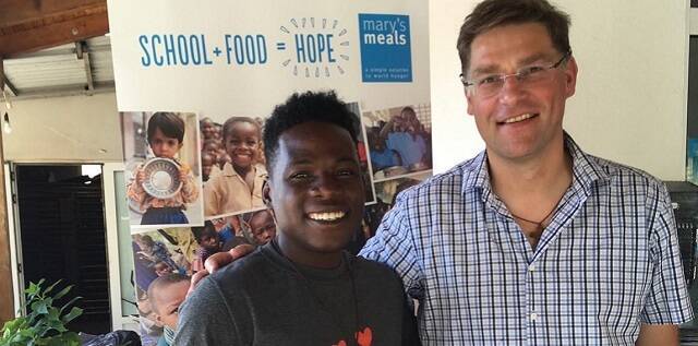 Magnus, fundador de Marys Meals, con un joven haitiano, antiguo beneficiado, hoy colaborador