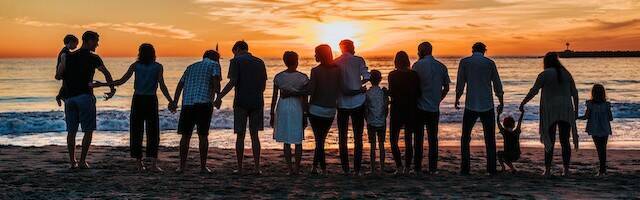 Familia en una playa ante el atardecer.