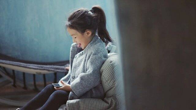 Una niña con teléfono móvil.